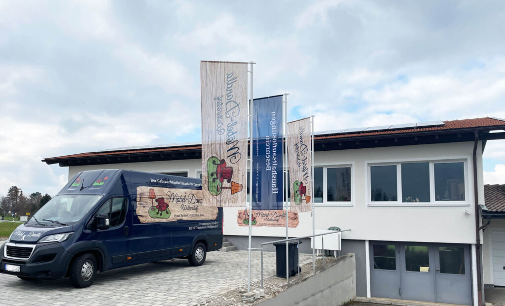 Sprinter steht vor Möbel-Dandla Gebäude mit Fahnen